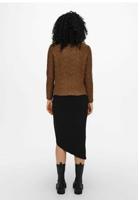 Brązowy sweter dzianinowy z długimi rękawami, zestawiony z czarną prążkowaną spódnicą midi z asymetrycznym dołem, noszony z czarnymi botkami za kostkę.