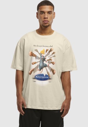 Mand iført beige t-shirt med "Ratatouille" rottefigur omgivet af knive og ost, med teksten "Han dør for at blive kok."