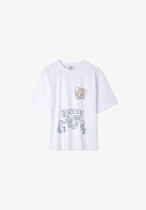 Camiseta blanca de manga corta con cuello redondo que presenta un diseño floral y flecos con el texto "CREATE LOVE" en el frente.