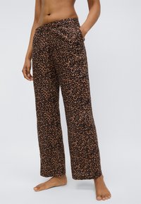 Pantalon marron à imprimé léopard avec une coupe décontractée, des poches latérales et une coupe droite. Tissu doux à texture lisse.
