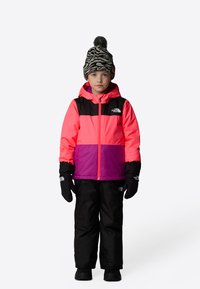 Bright pink and black jacket with purple stripe, paired with black pants and black gloves. The child wears a black and white patterned hat.