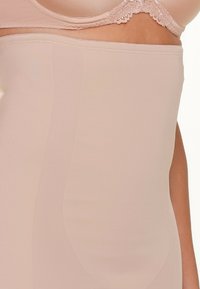 Beige shapewear met een gladde textuur, hoge taille ontwerp en geen zichtbare naden. Gemaakt van een zachte, rekbare stof voor comfort.
