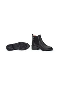 Botas negras hasta el tobillo con paneles elásticos en los laterales, detalles de tachuelas y suela de goma con estrías. Acabado en cuero suave, tacón bajo en bloque y forro rosa.