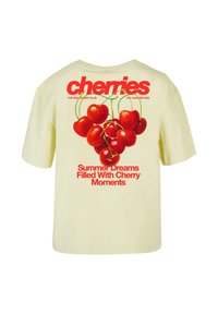 Cream T-shirt with red cherries graphic and text reading "cherries," "Summer Dreams Filled With Cherry Moments" on the back.
