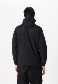 Sorte vandtætte jakke med hætte, der har elastiske manchetter og en enkel, glat tekstur. Bagsiden viser et minimalistisk design.