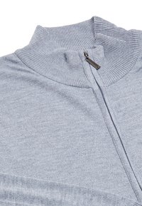 Sweater crem cu fermoar, cu guler ribatat și textură. Dispune de un cursor metallic la fermoar și un design curat și simplu.