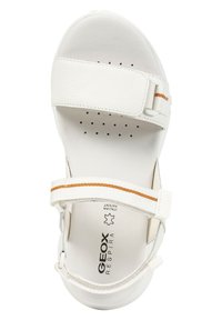 Vit sandal med en slät, blank yta och texturerad innersula. Har justerbara remmar med en horisontell orange rand och ventilationshål.