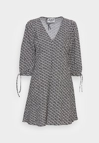 Šaty s černobílým vzorem, výstřihem do V, nabíranými rukávy a zavazováním na manžetách. Lehká látka s volně splývavým střihem.