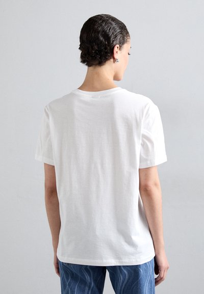 Hvit bomulls t-skjorte med rund hals og korte ermer, med en avslappet passform og glatt tekstur, brukt sammen med blå jeans.