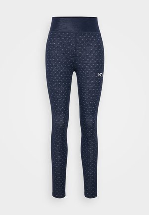 Marineblå sømløse leggings med små hvite hjerte mønstre, høy midjebånd, og hvit logo på øvre lår, frontansikt på hvit bakgrunn.