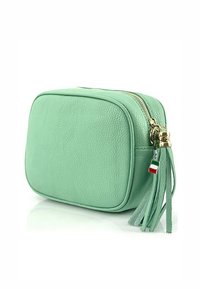 Mintgroene leren tas met een rechthoekige vorm, gouden rits en kwastdetail. Beschikt over een klein charm in de vorm van de Italiaanse vlag aan de rits.