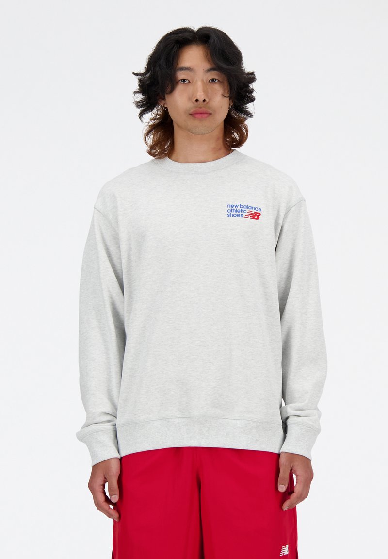 Sweat-shirt gris avec des poignets et un ourlet côtelés, arborant le logo multicolore "New Balance" sur la poitrine gauche. Tissu en mélange de coton.