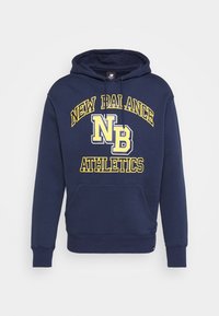 Sudadera azul marino con bolsillo frontal, capucha con cordón y texto gráfico amarillo que dice "New Balance NB Athletics". Material de mezcla de algodón.
