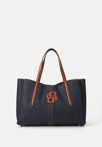 Denim-kangaskassi ruskeilla nahkahandleilla, jossa on näyttävä nahkalogo ja erottuva ompelu. Avoin yläosa, tilava muotoilu, suorakaiteen muotoinen.