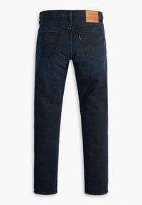 Jeans en denim bleu foncé avec jambes droites, conception à cinq poches et une étiquette en cuir de marque sur la ceinture arrière. Détails de coutures visibles.