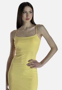 Vestito a canotta giallo con coste, spalline sottili, sagomatura aderente e texture liscia. Nessun motivo o dettaglio visibile.