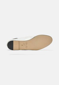 Suela de zapato de cuero blanco con una base de tono claro y un tacón negro. Presenta la firma embosada y el tamaño "37" cerca del tacón. Diseño plano.