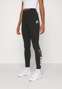 Svarta högmidjade leggings i stretchmaterial, med en vit Nike-logotyp på låret och "NIKE AIR" tryckt vertikalt på underbenet.