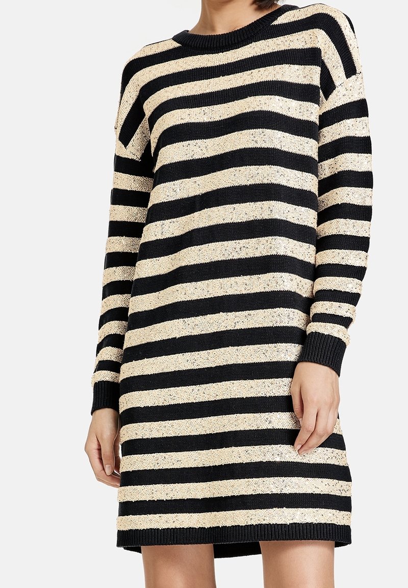 Gebreide trui jurk met zwarte en beige horizontale strepen, ronde hals, lange mouwen en geribbelde manchetten en zoom. Gestructureerde stof.
