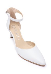 Vit läderpumps med ankelsrem, spetsig tå, låg klack och utskuren design. Har en beige insida med silverfärgad märkning.