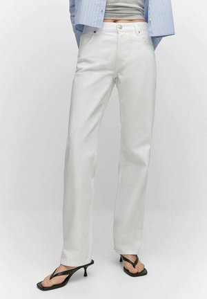 Person wearing high-waist straight white pants paired with black kitten heel sandals and a gray cropped top under a blue striped shirt.