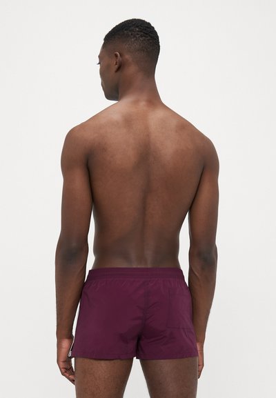 Bordeauxfarbene Badehorts aus leichtem, strukturiertem Stoff. Elastischer Bund mit einer Gesäßtasche. Kurze Länge, entworfen für eine figurbetonte Silhouette.