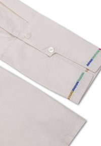 Lichtrompe shirt met knoopsluiting, voorzien van geborduurde accenten in groen, blauw, paars en goud op de mouwen. Glad katoenmateriaal, klassiek design.