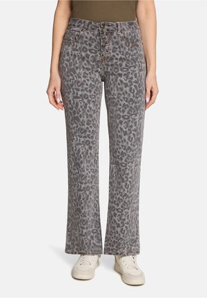 Grå leopardmønstret jeans med lige ben, høj talje og knaplukning, båret med hvide sneakers og en brun top.