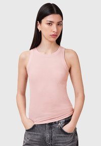 Top a righe rosa con scollatura rotonda e senza maniche, abbinato a jeans grigio scuro con una vestibilità ampia e tasche.