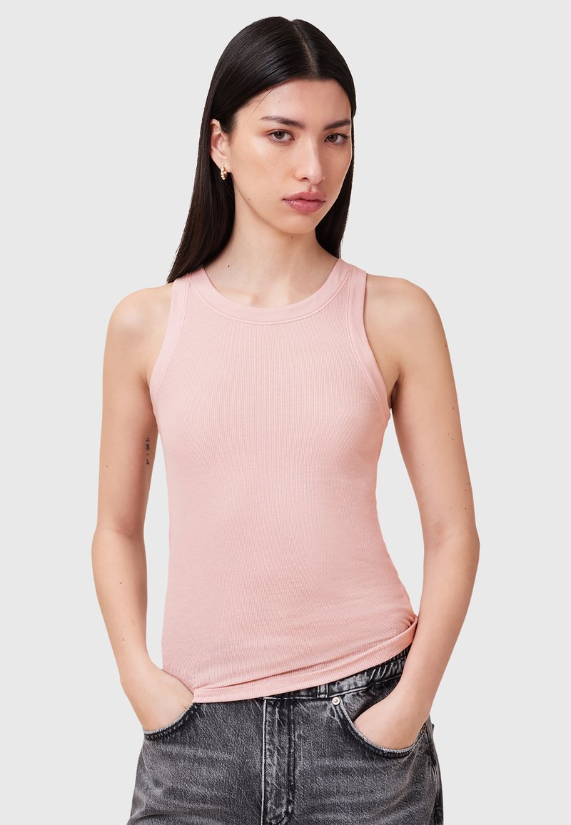 Top a righe rosa con scollatura rotonda e senza maniche, abbinato a jeans grigio scuro con una vestibilità ampia e tasche.