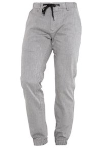 Pantalon gris clair en tissu texturé, doté d'une taille élastique avec un cordon noir et de poignets fuselés aux chevilles.