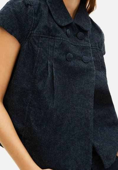 Top corto in denim scuro con maniche corte, colletto, due grandi bottoni e una vestibilità comoda con leggere pieghe decorative.