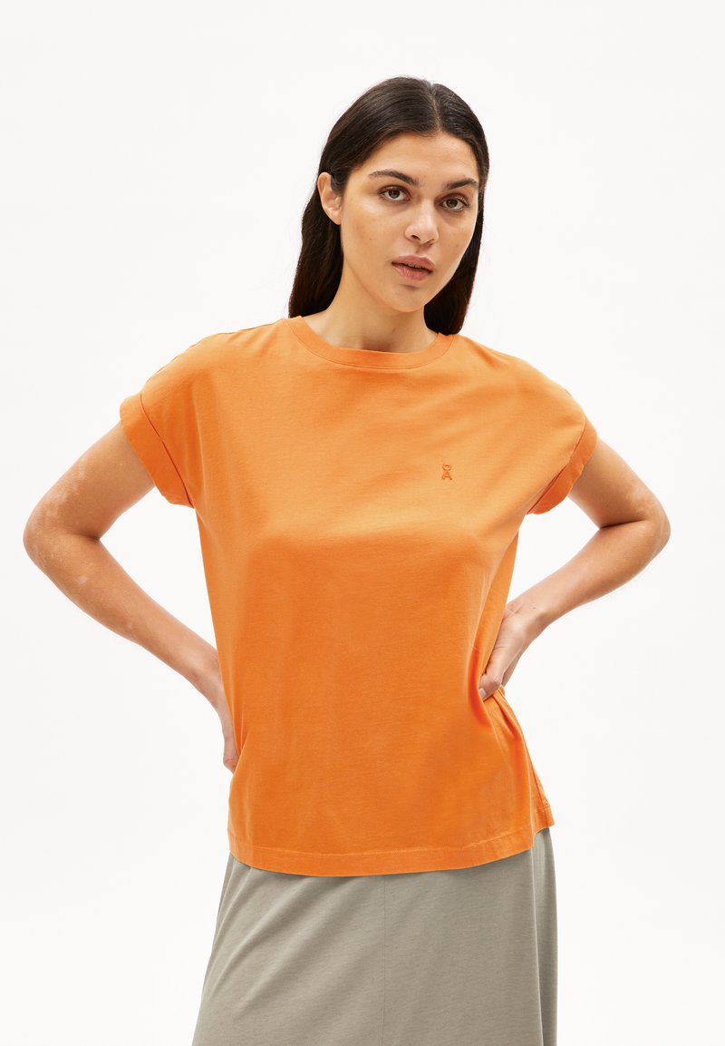 T-shirt in cotone arancione con maniche corte arrotolate e scollo rotondo. Presenta un piccolo dettaglio ricamato sul petto. Tessuto morbido.