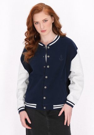 Navy ja vägrey varsity-jakk, kus on nupuga disain, kontrastsete varrukatega, triibuliste mansettidega ja tikitud ankurdetaile rinnal.
