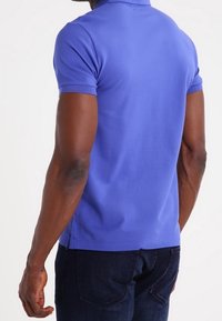 Korte mouwen polo shirt in een levendige blauwe kleur, met een klassieke kraag, zacht materiaal en een aansluitend ontwerp. Subtiele stikdetails aan de zoom.