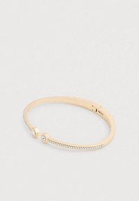 Aranyszínű fém karkötő két hatszögletű díszítéssel, az egyikben apró kristály, finom sorban tiszta drágakövekkel.