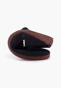 Zwarte stoffen slip-on sandaal met een gestructureerde bovenkant, gebogen ontwerp en een bruine rubberen zool. Flexibel en compact wanneer opgevouwen.