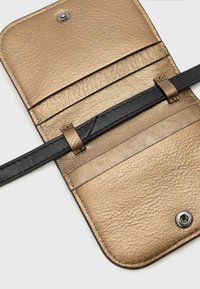 Billetera de cuero metálico dorado con correa de cuero negro, que cuenta con múltiples ranuras para tarjetas y un interior texturizado. Cierre de presión para una seguridad adicional.