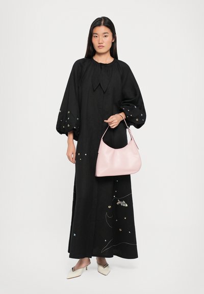 Zwarte lange mouwen jurk met geborduurde sterren; losse pasvorm en een strikdetail bij de kraag. Roze handtas met een gladde textuur. Crème puntige flats.