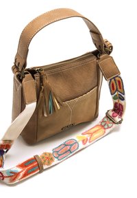 Borsa in pelle color cuoio con superficie testurizzata, dotata di chiusura con cerniera, dettaglio con nappina e una tracolla ricamata colorata con motivi floreali.