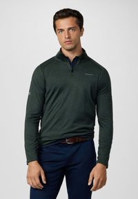 Dunkelgrüner Pullover mit langen Ärmeln und einem Viertel-Reißverschluss-Kragen, der eine dezente Melange-Textur und Logo-Details auf der Brust und dem Ärmel aufweist.