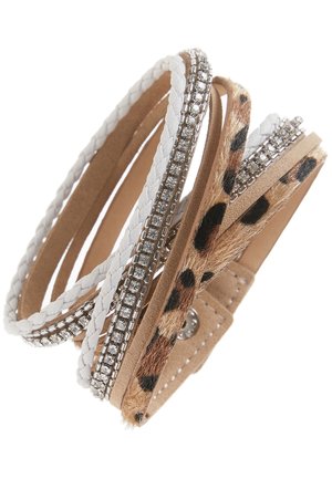 Bracelet multicouche avec des brins tressés blancs, des chaînes en strass, une bande lisse couleur fauve et une bande en fourrure imprimé léopard fixée par un bouton-pression.
