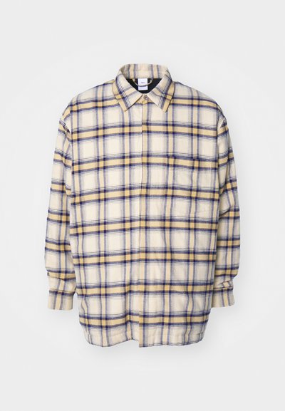 Kreemikas nööpidega särk siniste ja kollaste ruuduste mustritega. Pikkade varrukatega, mugav lõige ja klassikaline krae. Pehme, tekstureeritud kangas.