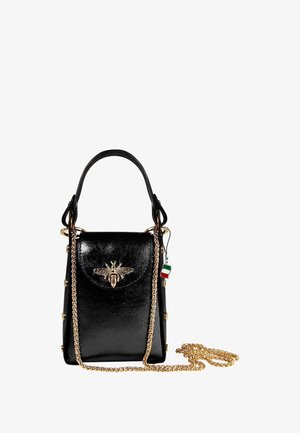 Sac à main en cuir noir au design structuré, avec un emblème d'abeille en or sur le devant, une bandoulière en chaîne et des clous décoratifs le long des côtés.