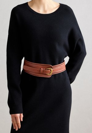 Black knitted dress with long sleeves, accented by a wide brown leather belt featuring a gold buckle and decorative perforations along the edges.
