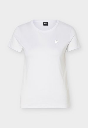 Balta īsroku T-krekls ar apaļu kaklu, kreisajā krūtīs neliels metālisks logotipa uzraksts un melna zīmola etiķete apkakles iekšpusē.