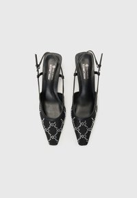 Black vegan slingback heels with pointed toes, embellished with silver rhinestones in a diamond pattern on soft fabric. Square heel design.