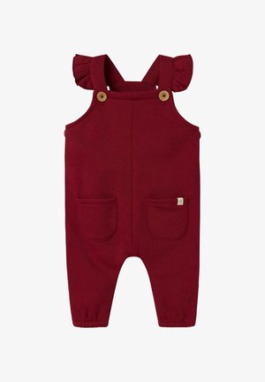 Rdeča pletena kombinezona z nabranimi naramnicami, lesenimi gumbi, dvema sprednjima žepoma in elastiziranimi manšetami na gležnjih. Mehka, trpežna tkanina.