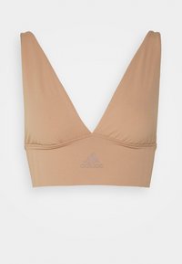 Šviesiai smėlinis sportinis braletas su giliu V formos dekolte, pagamintas iš glotnaus audinio. Puikuojasi adidas logotipu, kuris yra šiek tiek tamsesnės spalvos.