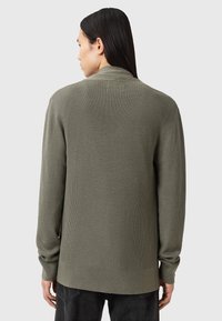 Cárdigan de canalé verde oliva con mangas largas, un cuello con chal y un dobladillo recto. Tejido texturizado con un corte relajado y sin cierres visibles.